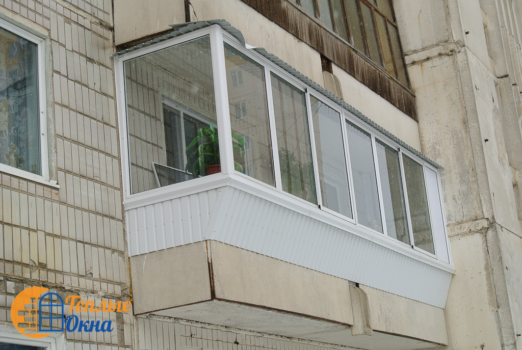 Балкон в панельном доме 75 серии, фото остекления балкона с выдвижением 30 см. Наружная обшивка профнастилом. Широкий белый подоконник.